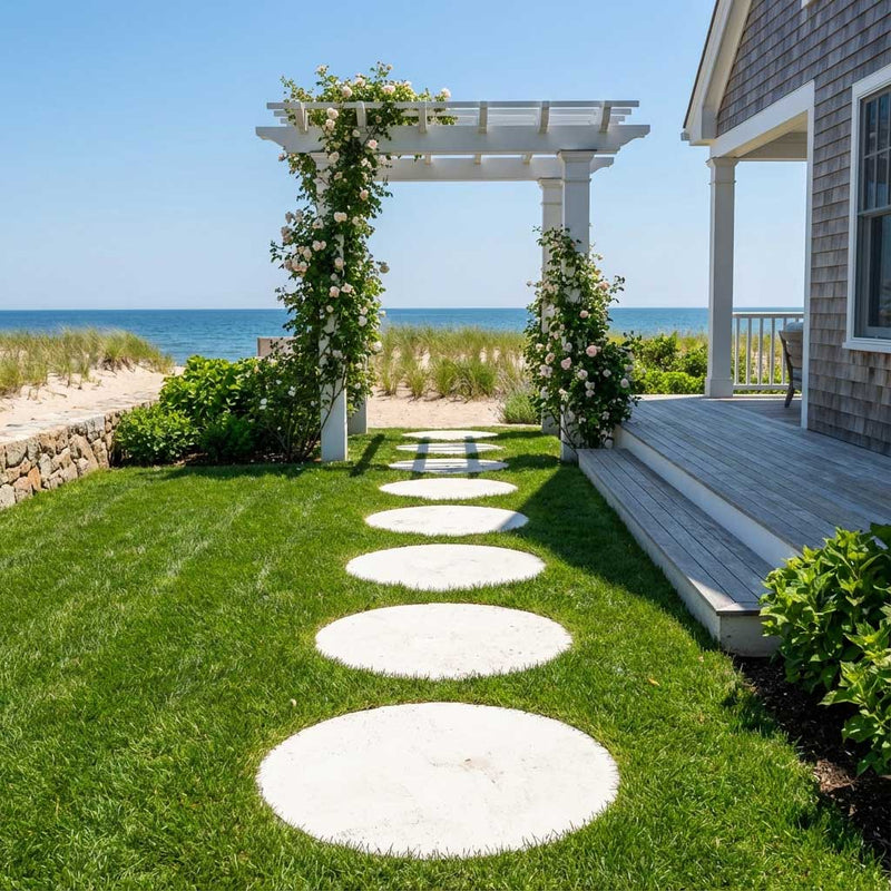 Limestone Stepping stone path leading to a white pergola with floral decorations, set against a beach backdrop.